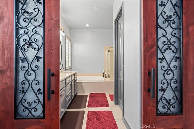 bathroom featuring tile patterned flooring, vanity, and a bathtub