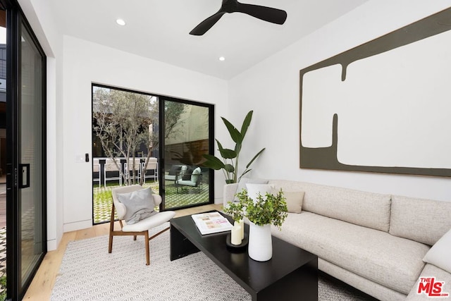 living room featuring light wood-type flooring and ceiling fan