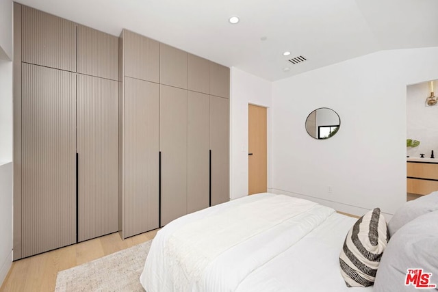 bedroom featuring light hardwood / wood-style flooring and vaulted ceiling