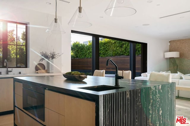 kitchen with hanging light fixtures, a healthy amount of sunlight, and sink