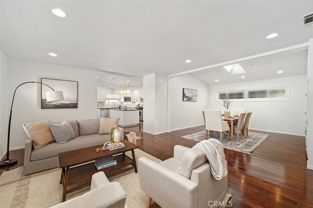 living room featuring lofted ceiling with skylight and hardwood / wood-style floors