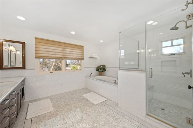 bathroom featuring vanity, shower with separate bathtub, tile walls, and tile patterned floors