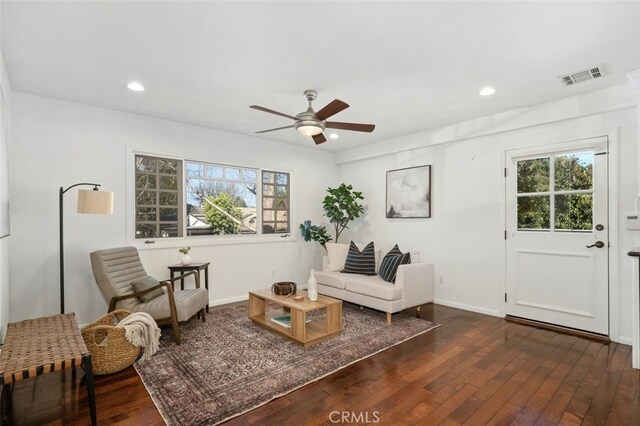 living area with dark wood-type flooring and ceiling fan