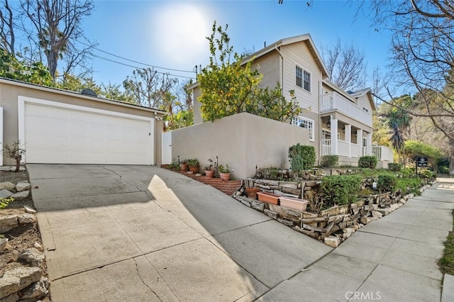 view of side of home featuring a balcony and a garage