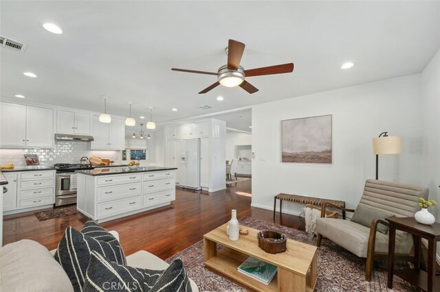 living room with dark wood-type flooring and ceiling fan