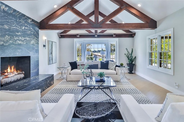 living room featuring a premium fireplace, hardwood / wood-style flooring, and lofted ceiling with beams