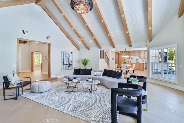 living room featuring high vaulted ceiling, beam ceiling, a notable chandelier, and light hardwood / wood-style floors