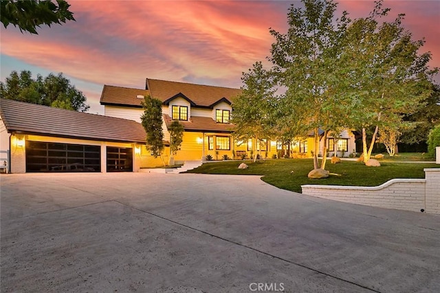 view of front of house with a garage and a yard