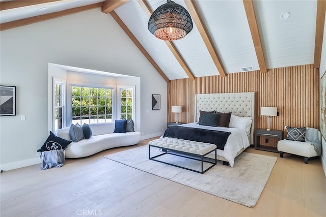 bedroom featuring high vaulted ceiling, beam ceiling, wooden walls, and light hardwood / wood-style floors