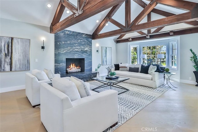 living room with light hardwood / wood-style floors, lofted ceiling with beams, and a fireplace