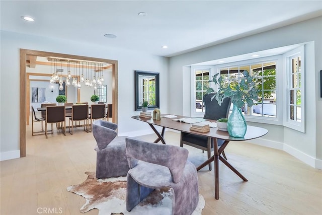 home office featuring a wealth of natural light, a chandelier, and light wood-type flooring