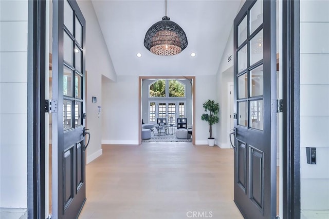 entryway with lofted ceiling, french doors, and hardwood / wood-style floors