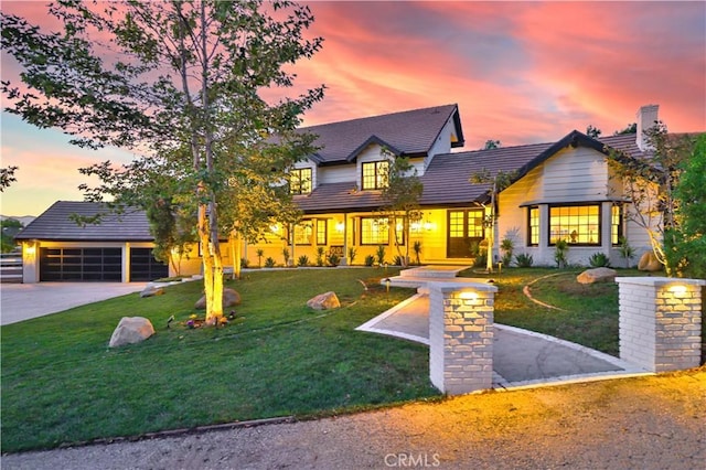 view of front of property with a garage and a lawn