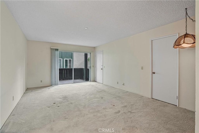 unfurnished room with a textured ceiling and light colored carpet