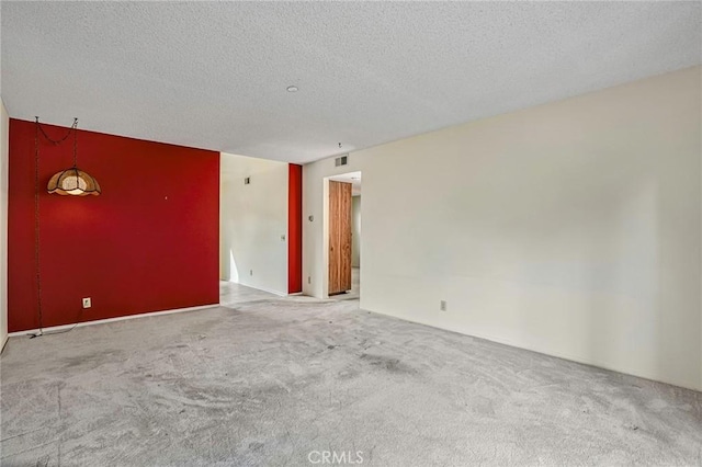 carpeted empty room with a textured ceiling