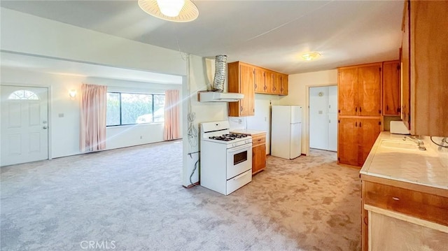 kitchen with wall chimney range hood, sink, light colored carpet, and white appliances