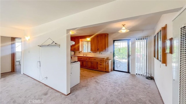 kitchen with light colored carpet and washer / dryer