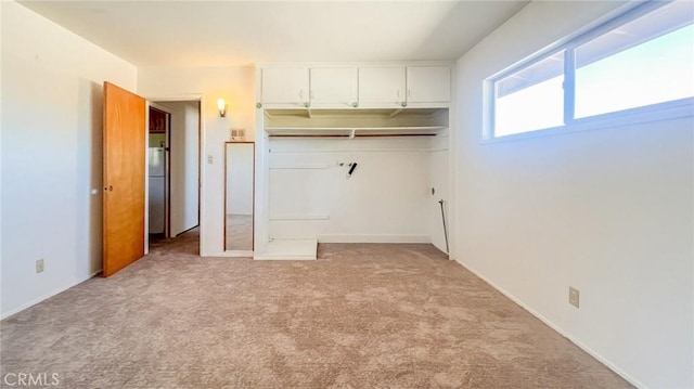 interior space featuring a closet, light colored carpet, and fridge