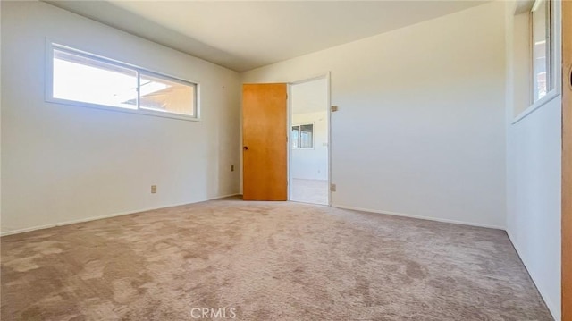 carpeted empty room with vaulted ceiling