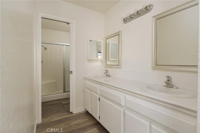 bathroom with a shower with shower door, wood-type flooring, and vanity