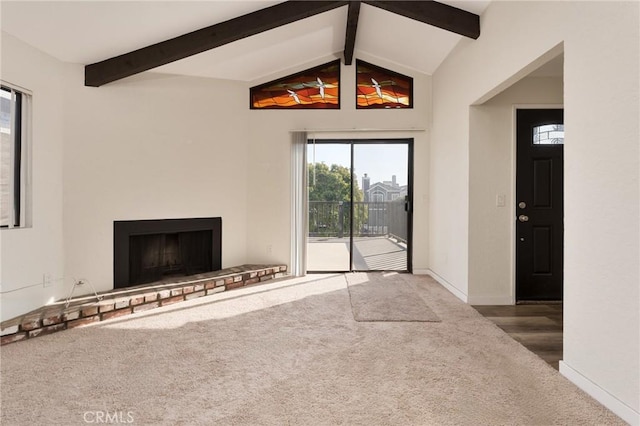 unfurnished living room featuring carpet and vaulted ceiling with beams