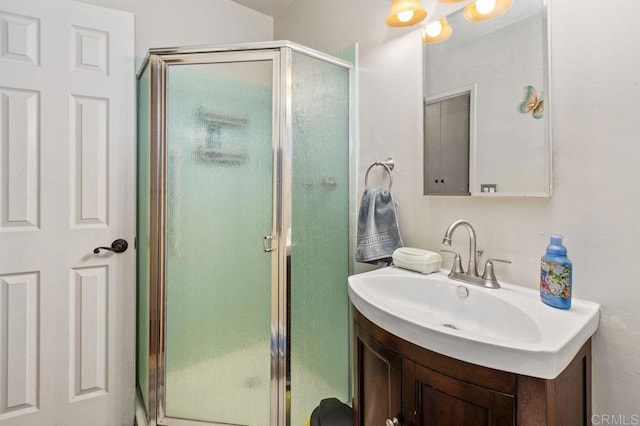 bathroom featuring vanity and a shower with door