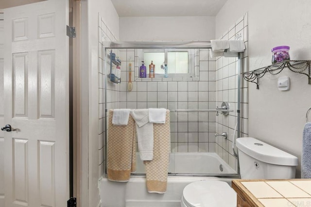 bathroom with toilet and bath / shower combo with glass door