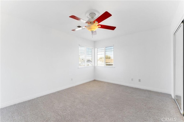 carpeted empty room with baseboards and a ceiling fan