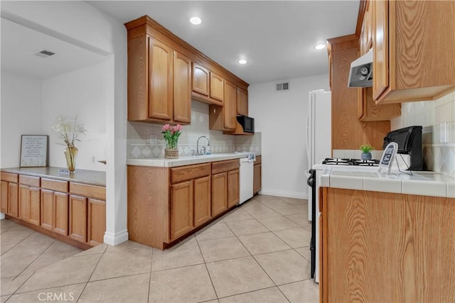 kitchen with black microwave, range hood, visible vents, and dishwasher