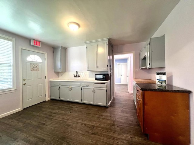 kitchen with dark wood-type flooring, white cabinets, and sink