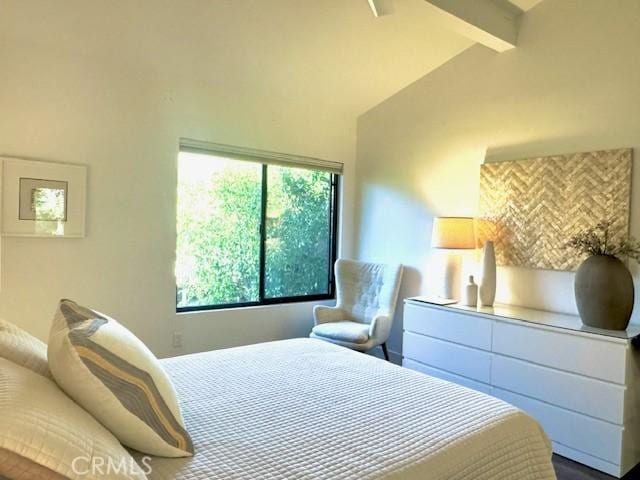 bedroom featuring vaulted ceiling with beams