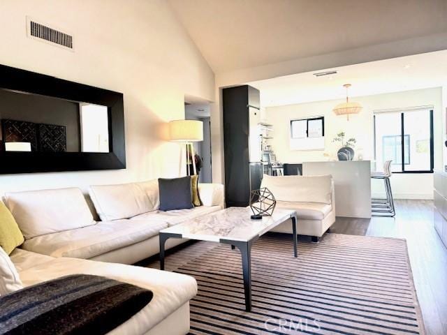 living room featuring hardwood / wood-style flooring and high vaulted ceiling