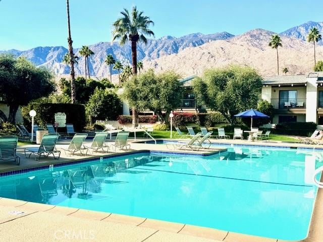 view of swimming pool with a patio area and a mountain view