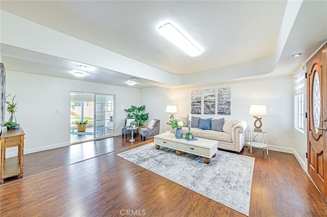 living room featuring plenty of natural light and dark hardwood / wood-style flooring