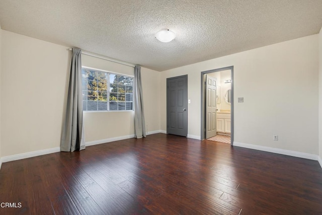 empty room featuring a textured ceiling and dark hardwood / wood-style floors