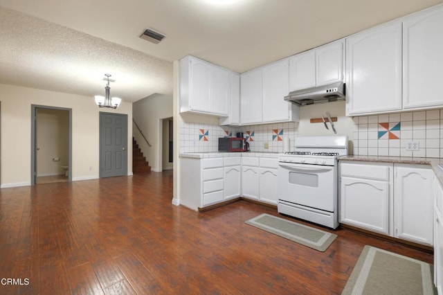 kitchen featuring decorative backsplash, white range, a chandelier, white cabinetry, and hanging light fixtures