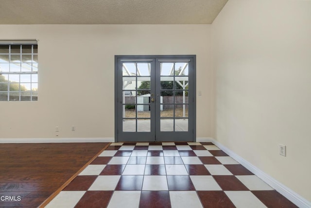 entrance foyer with french doors and a textured ceiling