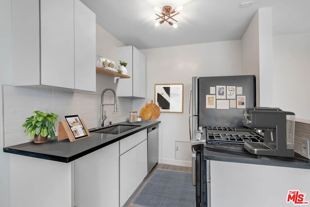 kitchen featuring backsplash, appliances with stainless steel finishes, sink, and white cabinetry