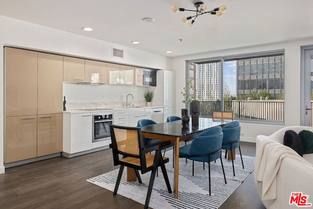 dining area featuring sink, dark hardwood / wood-style flooring, and a chandelier