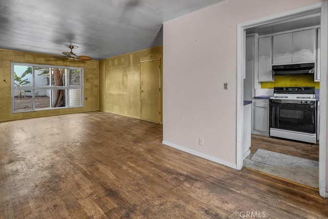 unfurnished living room featuring dark wood-type flooring and ceiling fan