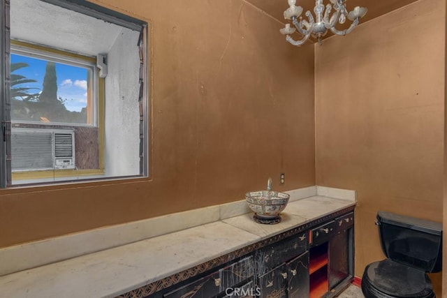 bathroom featuring toilet, vanity, and a notable chandelier