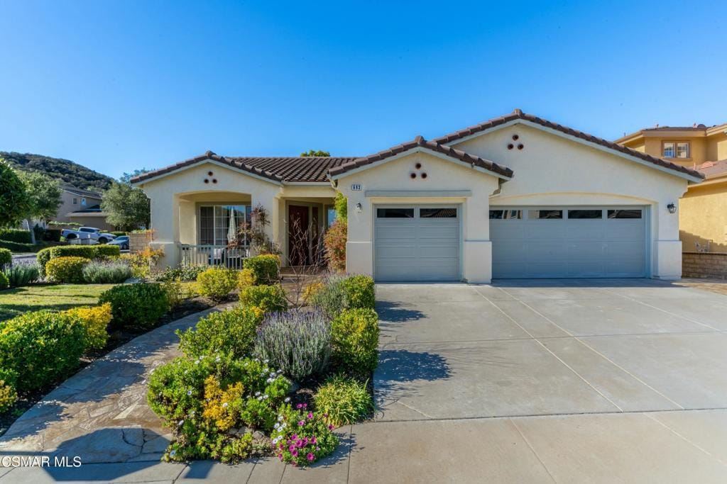 mediterranean / spanish-style house with a garage and a porch