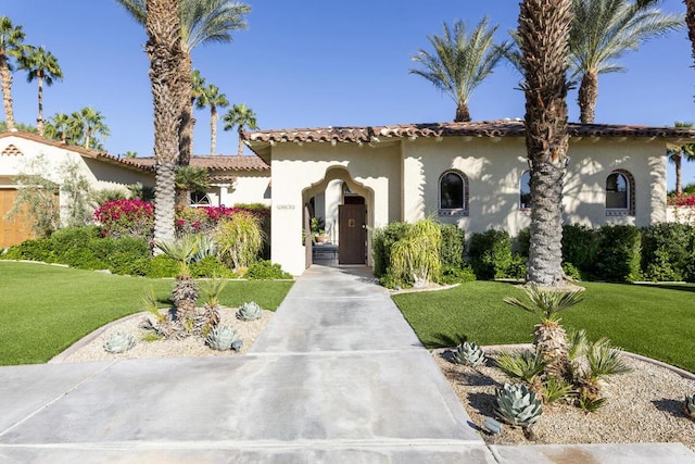 mediterranean / spanish home with a front yard