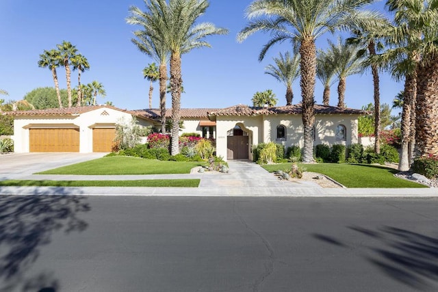 mediterranean / spanish home featuring a garage and a front yard