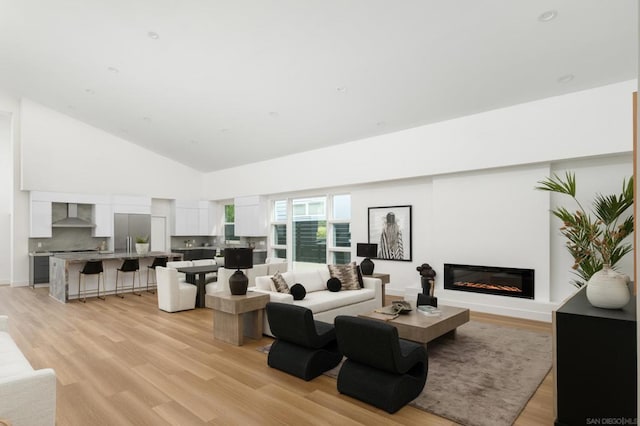 living room with high vaulted ceiling and light hardwood / wood-style floors