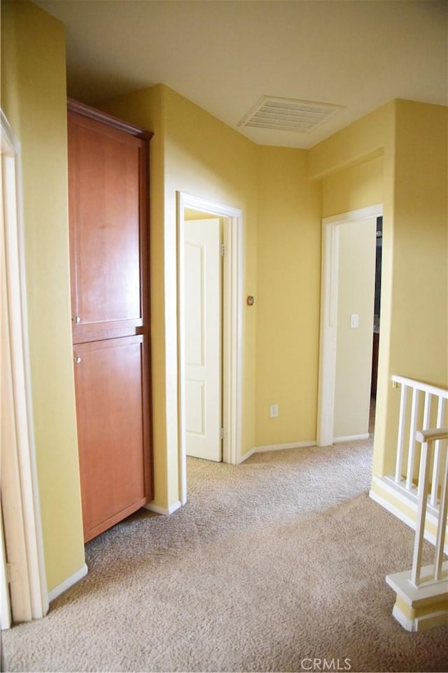 hallway featuring light colored carpet