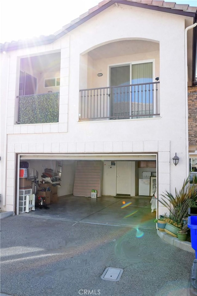 rear view of house with a balcony and a garage