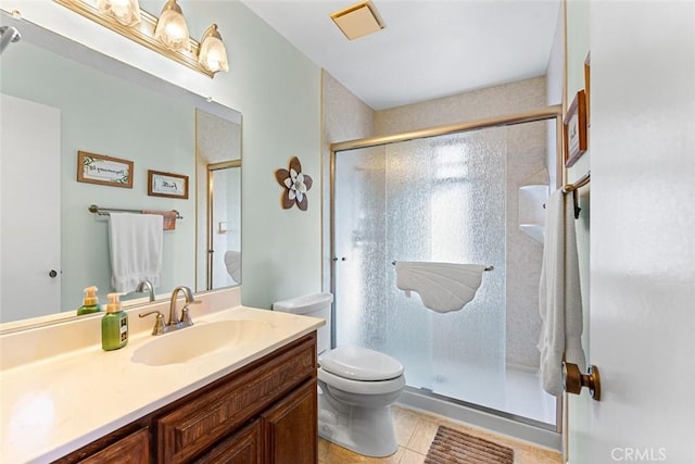 bathroom featuring walk in shower, vanity, tile patterned floors, and toilet