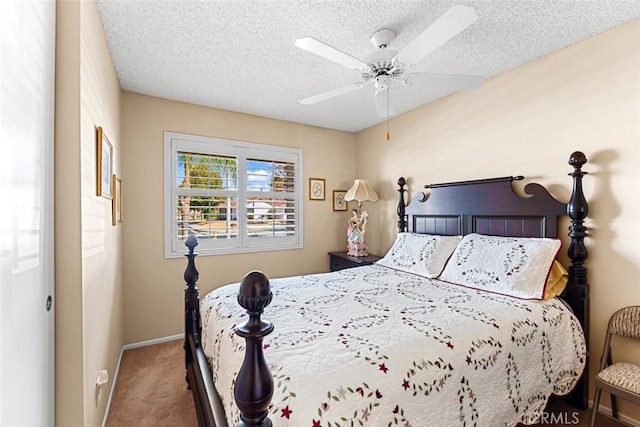 bedroom with ceiling fan, carpet floors, and a textured ceiling