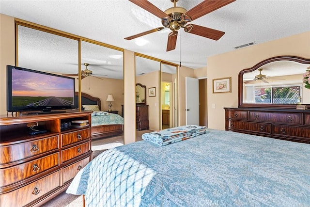 bedroom with ceiling fan and a textured ceiling